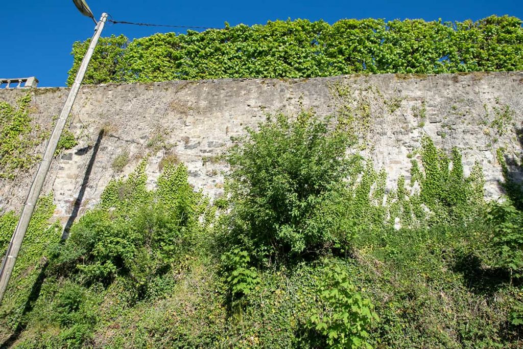 Mur massif de huit à dix mètres de hauteur, en moellons à joints larges