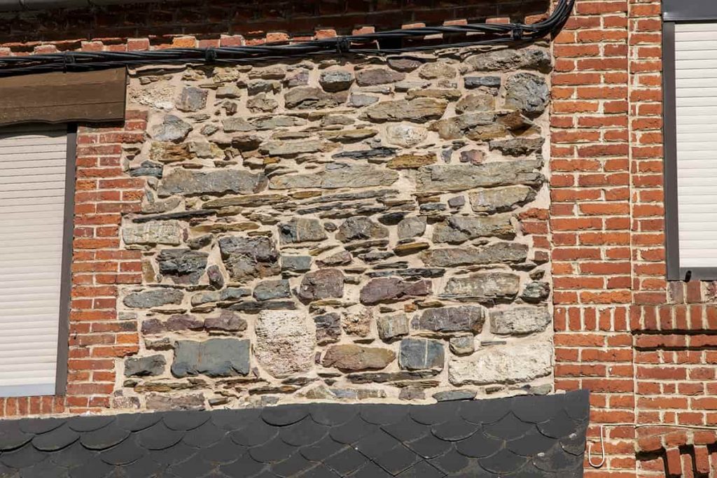 Maison de remploi présentant un mur en moellons hétérogènes